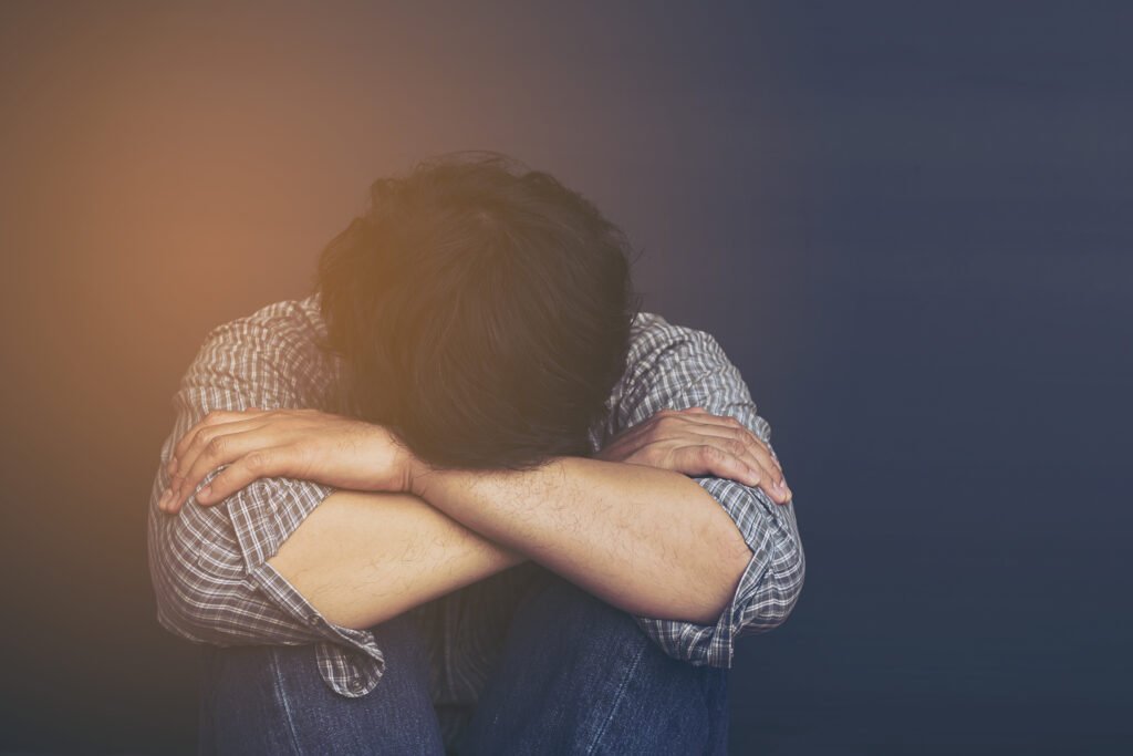 sad man holding head with hand